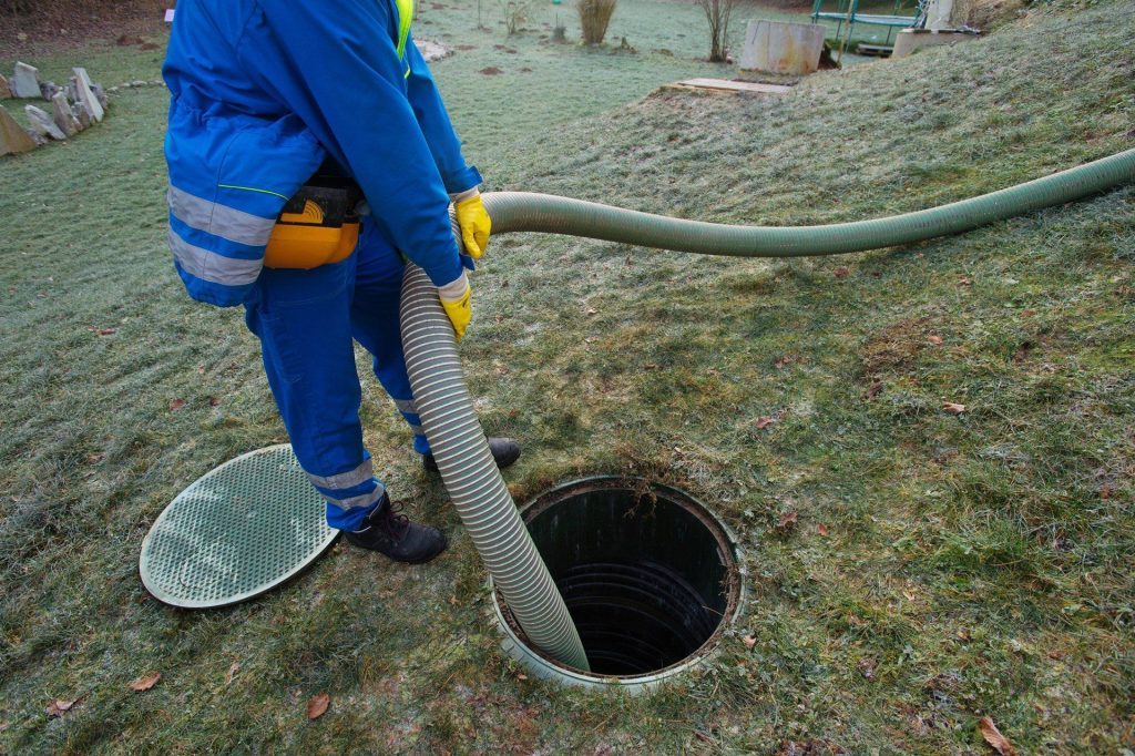Maintenance worker conducting drain cleaning in sewer