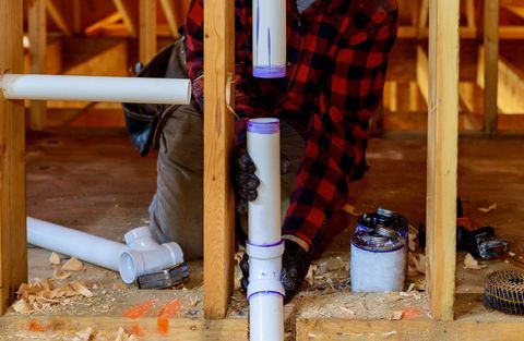 A plumber installs PVC pipes