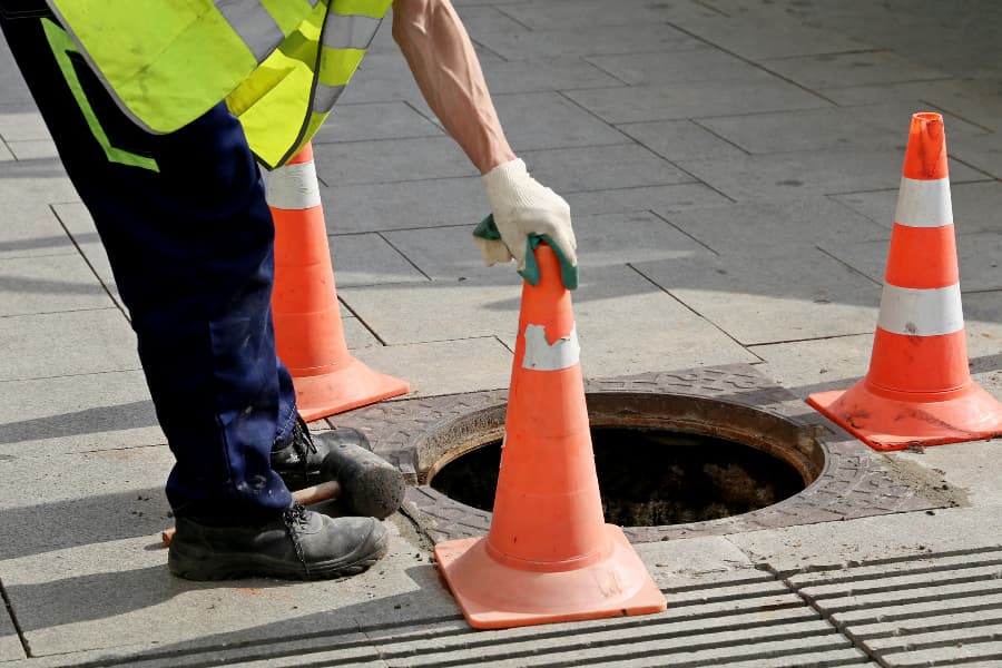 Orange cones blocking off manhole to city sewer line