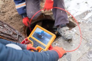 Technicians insert camera to visualize and plan trenchless sewer repair