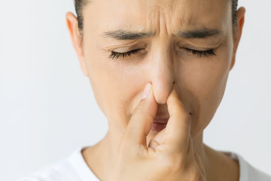 Homeowner plugging nose due to stench from failing septic system