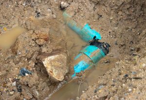 Broken plastic plumbing pipe in dirt hole