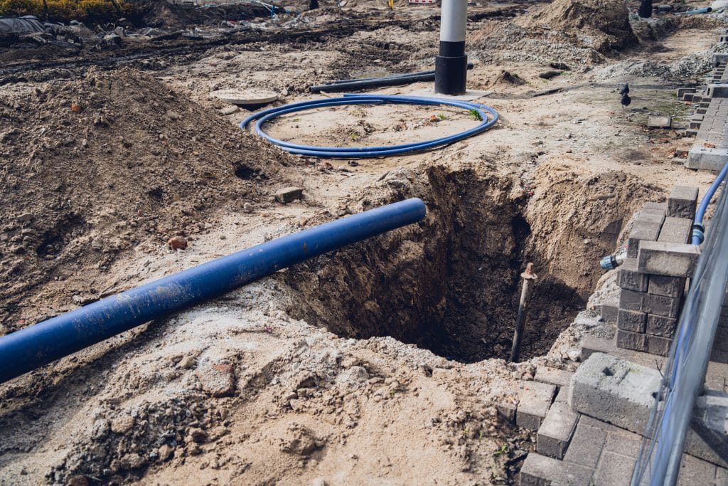 Excavation site with pipes and wires ready to be buried