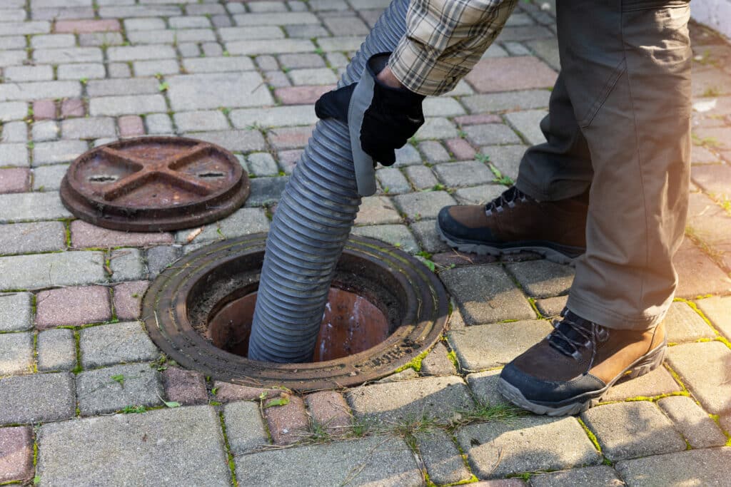 worker-holding-pipe-and-pumping-out-household-septic-tank